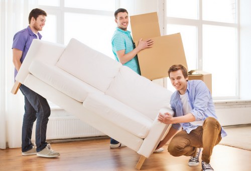 Removal team carrying student belongings through a Borough residential street